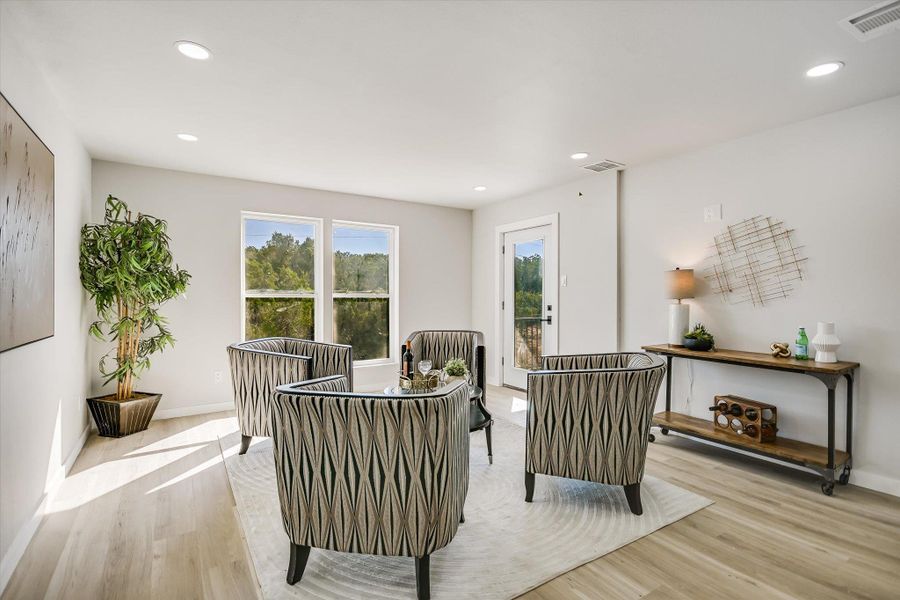 Recessed lighting and ample natural light illuminate this inviting living area with balcony access.