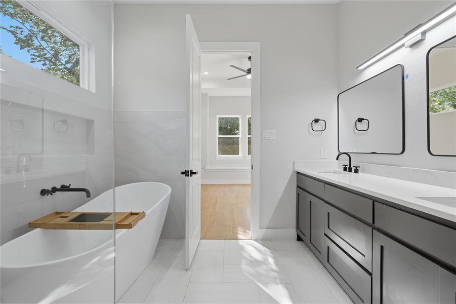 Contemporary bathroom featuring a freestanding tub, glass-enclosed shower, dual vanity with quartz countertop, and matte black fixtures Contemporary bathroom featuring a freestanding tub, glass-enclosed shower, dual vanity with quartz countertop, and matte black fixtures