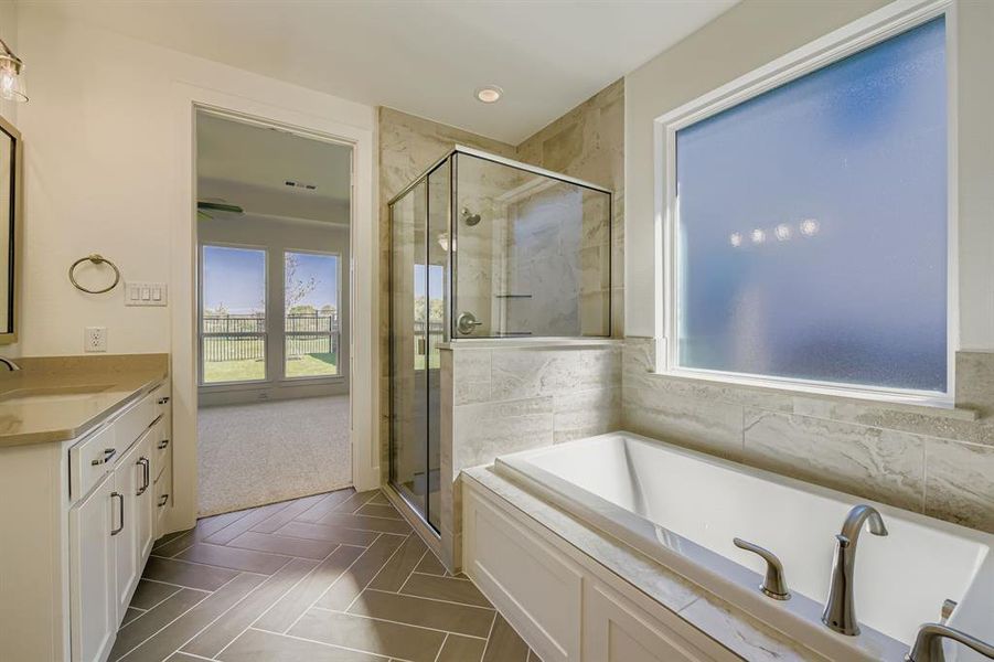Full bath with a stall shower, vanity, a garden tub, and recessed lighting