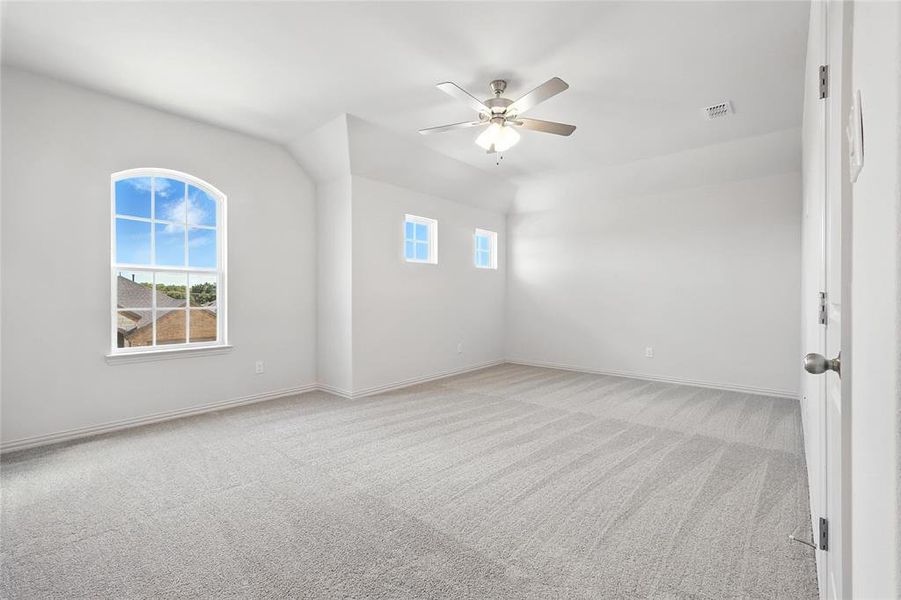 Unfurnished room featuring healthy amount of natural light, light colored carpet, and a ceiling fan Unfurnished room featuring healthy amount of natural light, light colored carpet, and a ceiling fan