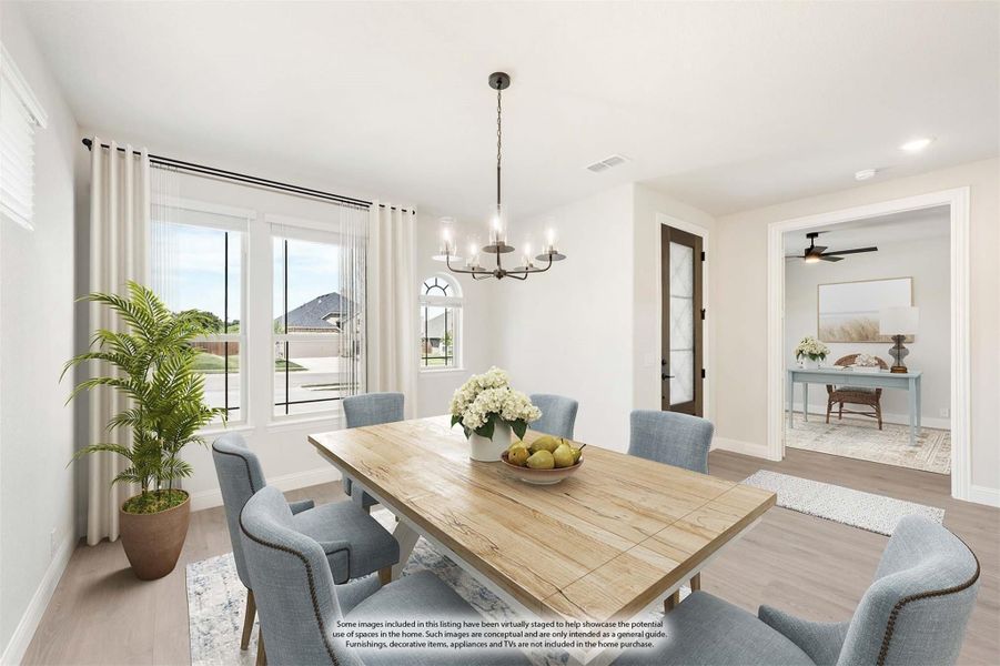 Dining room with wood table, blue upholstered chairs, chandelier, and large windows with natural light