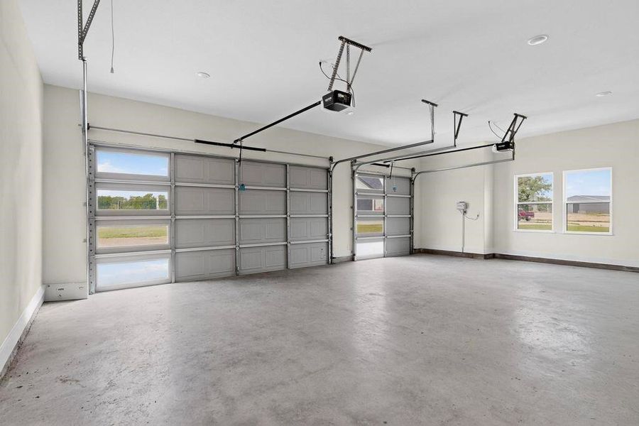 Garage featuring baseboards and a garage door opener Garage featuring baseboards and a garage door opener