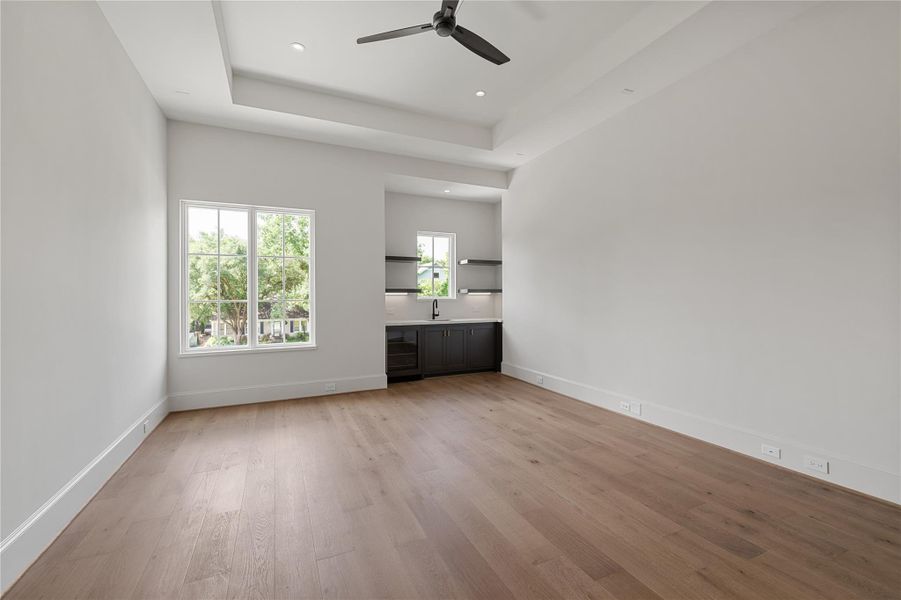 Towards the front of the home is the Media / Game room with wet bar and tray ceiling.