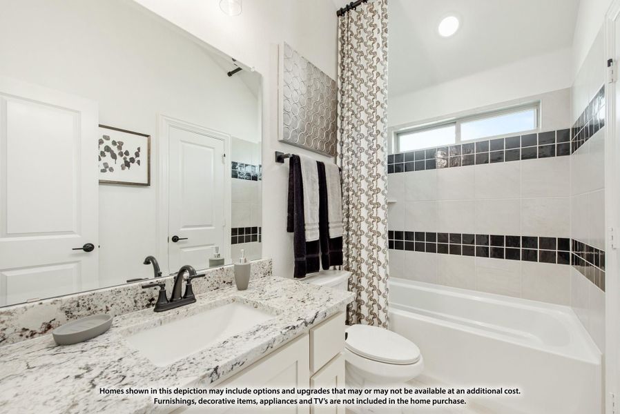 Bathroom with granite countertop, white cabinets, and tiled tub-shower combo with dark accent tiles