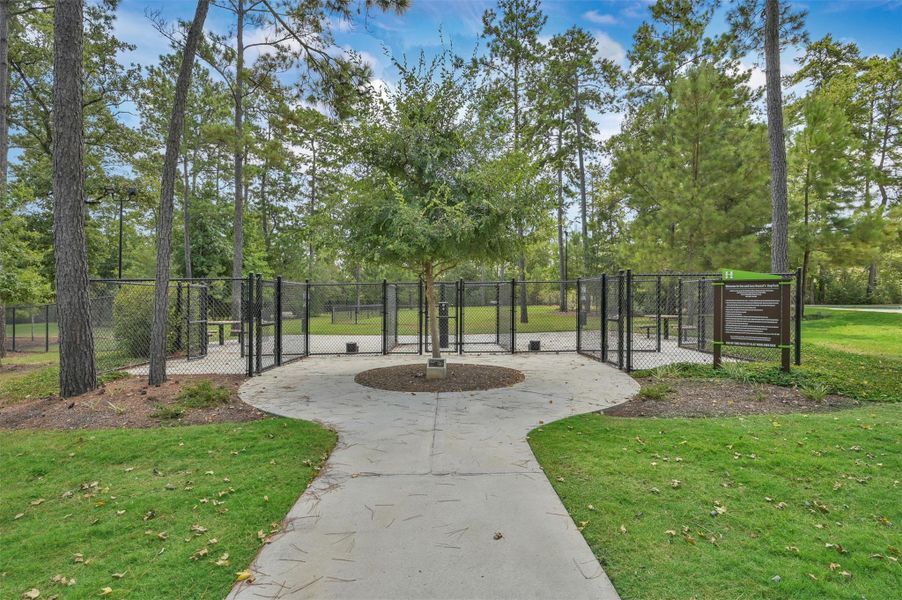 Community dog park featuring separate areas for large and small pets, complete with water stations and a convenient cleaning station for residents to clean up after their furry friends.