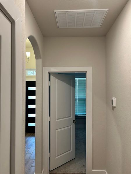 Elegant Hallway — Beautiful arched entryway leading to two bedrooms and a full bathroom, with flexible space ideal for a guest room or home office.