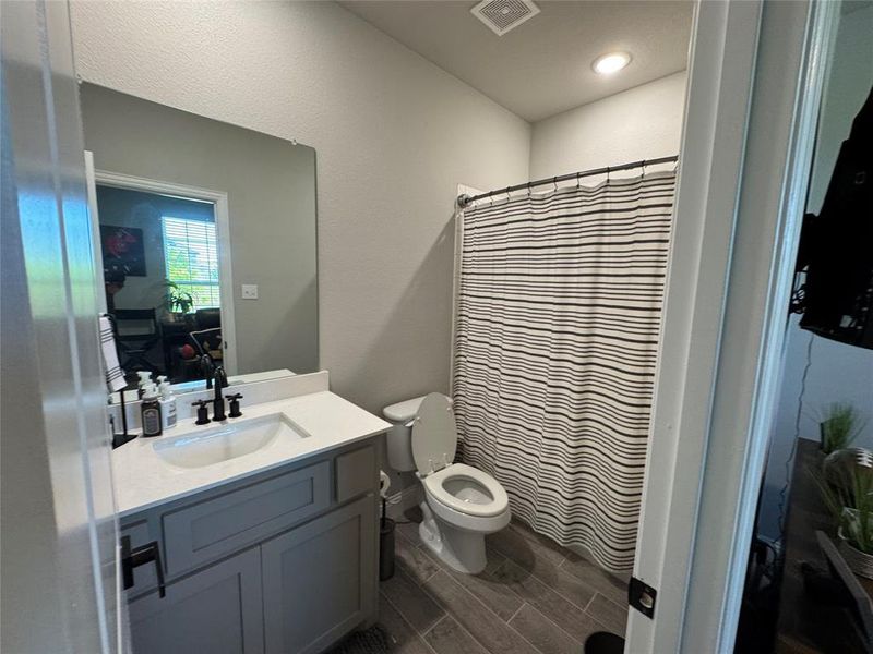 Bathroom with vanity, wood tiled floors, and curtained shower Bathroom with vanity, wood tiled floors, and curtained shower