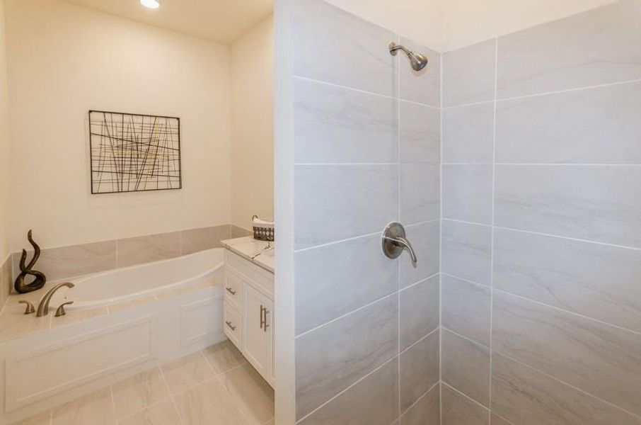 Bathroom with shower with separate bathtub, vanity, and tile patterned floors