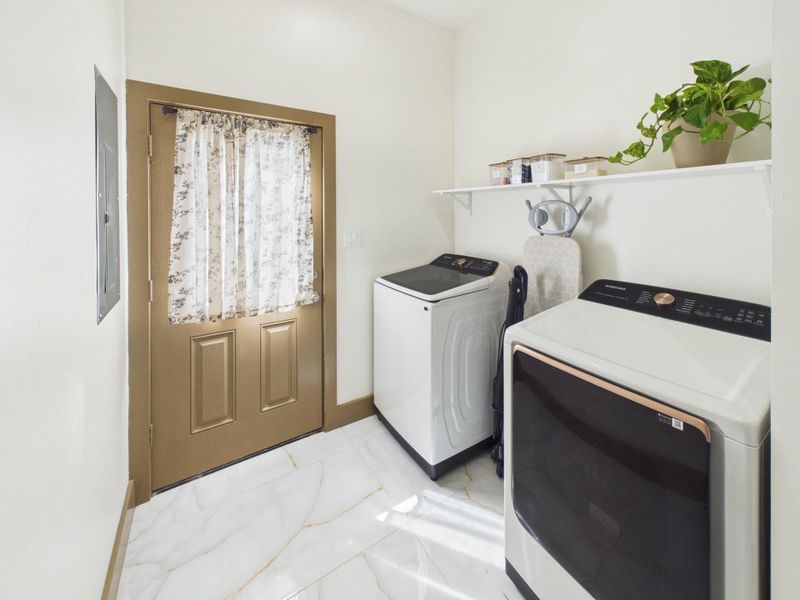 Dedicated laundry room with additional shelving and convenient exterior access