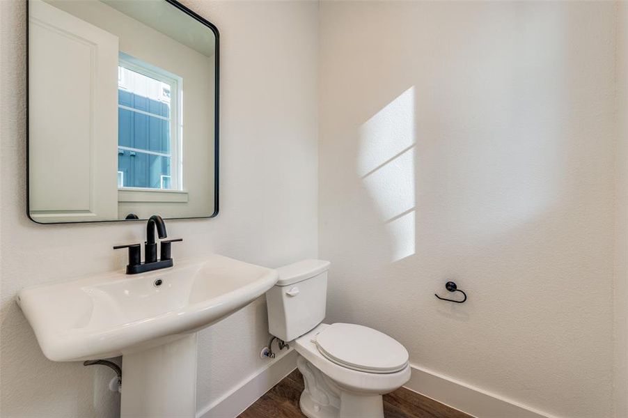 Bathroom with wood-type flooring, sink, and toilet