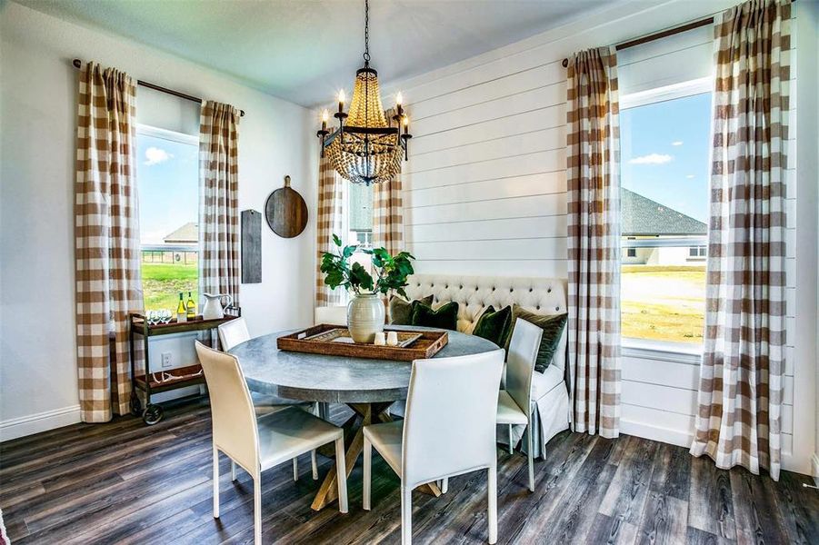 Dining area featuring a wealth of natural light, dark wood-type flooring, and an inviting chandelier