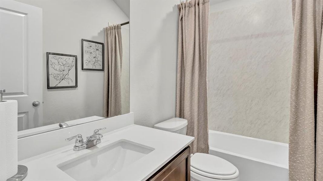 Bathroom featuring vanity and shower / bathtub combination with curtain Bathroom featuring vanity and shower / bathtub combination with curtain