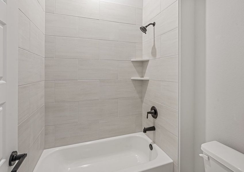 The secondary bathroom has a tiled shower-tub combo.
