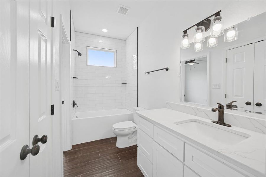Bathroom with vanity, bathing tub / shower combination, and wood tiled floors