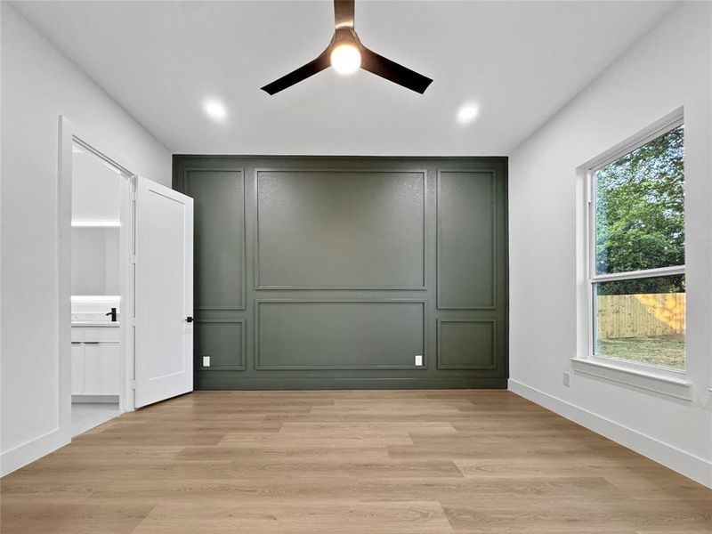 Unfurnished bedroom with light wood-style floors, a decorative wall, a ceiling fan, and recessed lighting