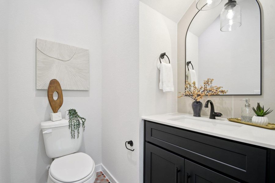 A compact and stylish powder room with modern fixtures, sleek cabinetry, and artful accents. A compact and stylish powder room with modern fixtures, sleek cabinetry, and artful accents.