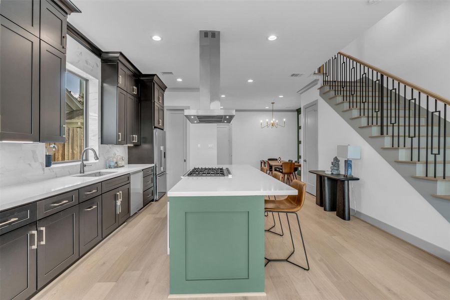 This view highlights the kitchen's spacious layout, featuring a center island that also serves as a convenient breakfast bar for casual dining and additional seating.