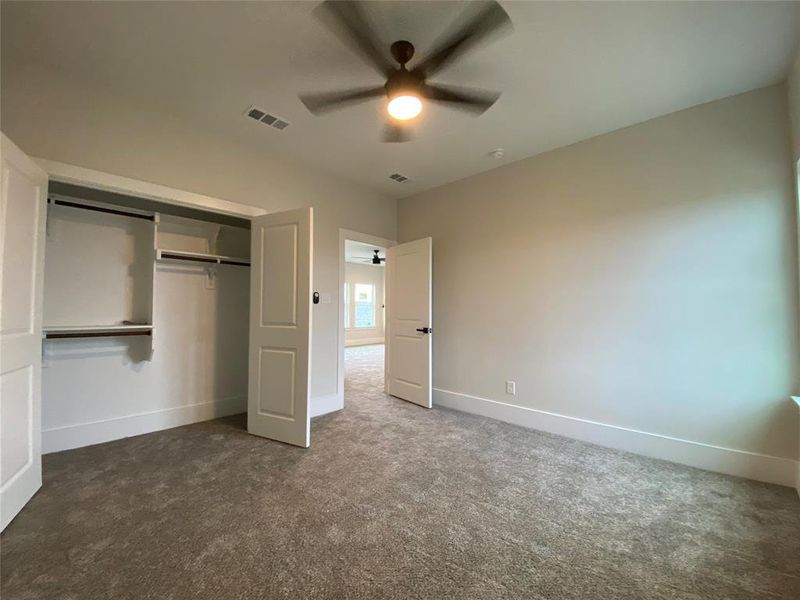 Unfurnished bedroom featuring carpet floors, ceiling fan, and a closet