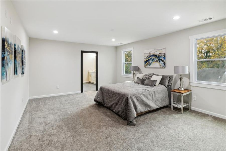 Bedroom with light carpet and ensuite bath