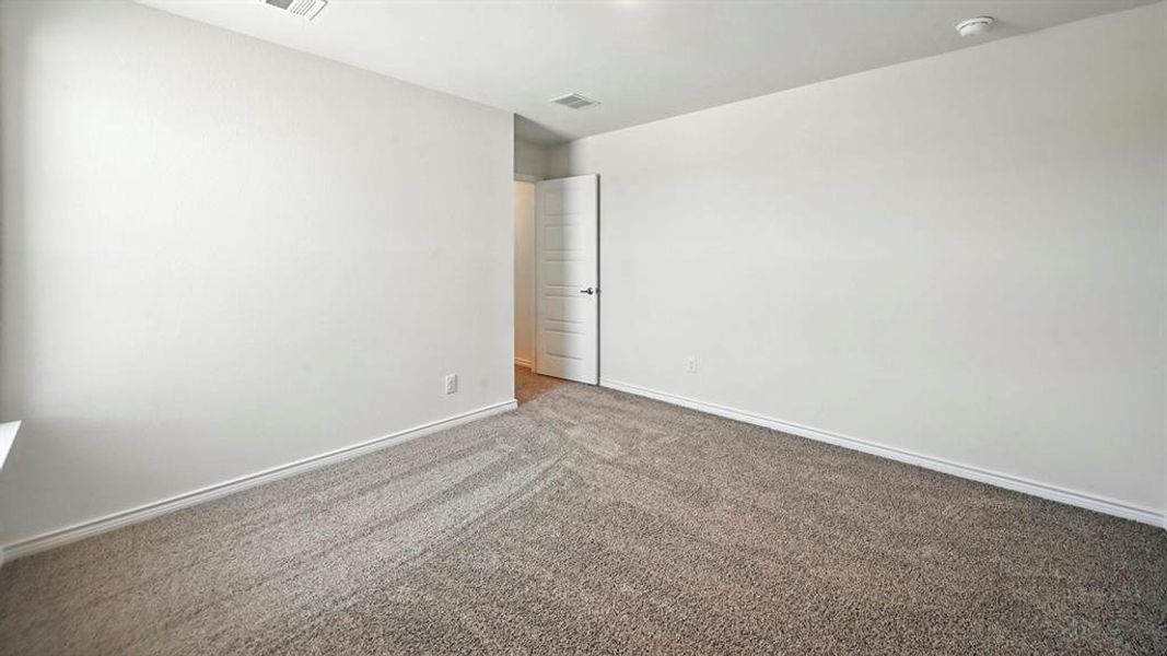 Empty room featuring carpet flooring and baseboards Empty room featuring carpet flooring and baseboards
