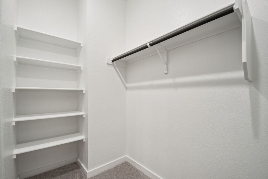 A white shelf with a metal bar.