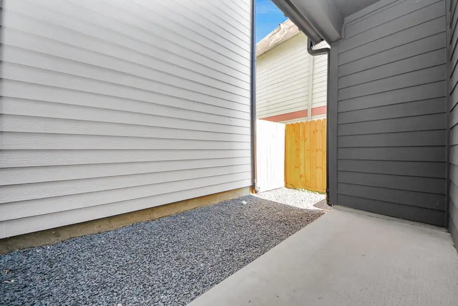 Step into this narrow outdoor side area between homes, with gravel ground and siding walls. A wooden fence at the end provides privacy while maintaining a clean and orderly appearance. Step into this narrow outdoor side area between homes, with gravel ground and siding walls. A wooden fence at the end provides privacy while maintaining a clean and orderly appearance.