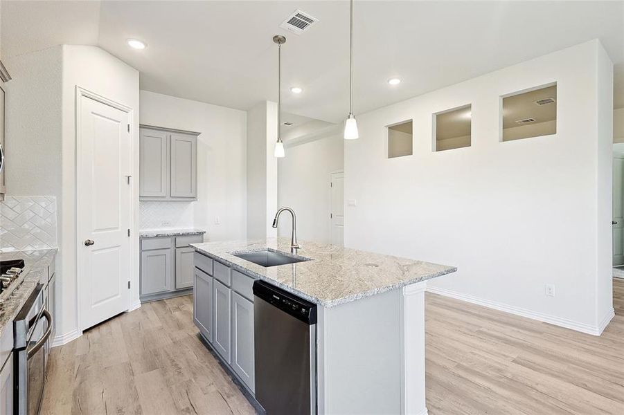 Kitchen with dishwasher, a center island with sink, tasteful backsplash, and sink