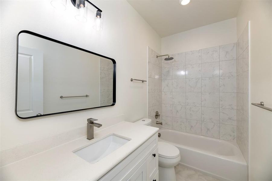Bathroom with shower / washtub combination, toilet, and vanity