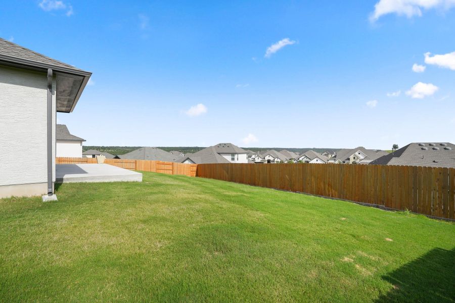 A generous backyard offers ample space for outdoor enjoyment and overlooks a neatly fenced perimeter.
