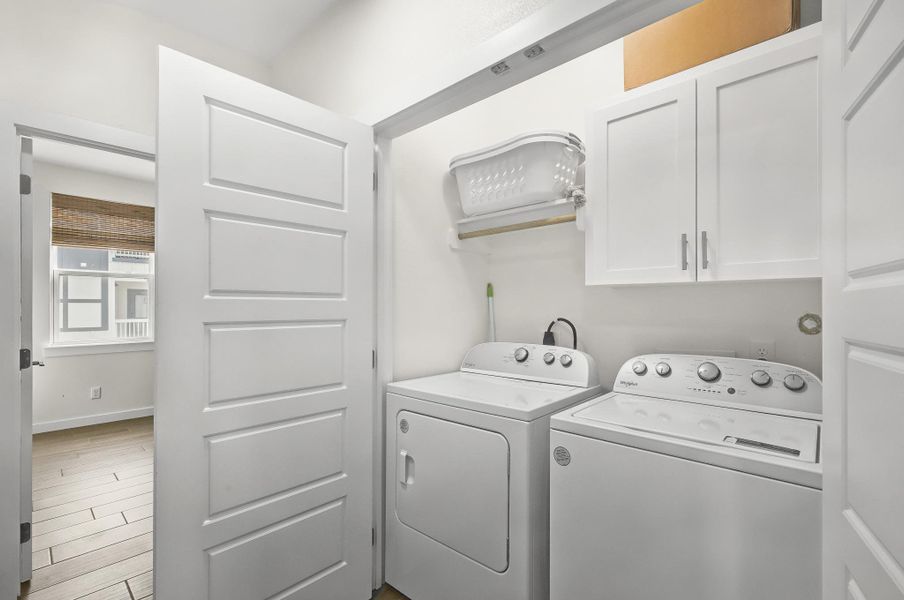 Laundry room with cabinet space, wood finished floors, and independent washer and dryer Laundry room with cabinet space, wood finished floors, and independent washer and dryer
