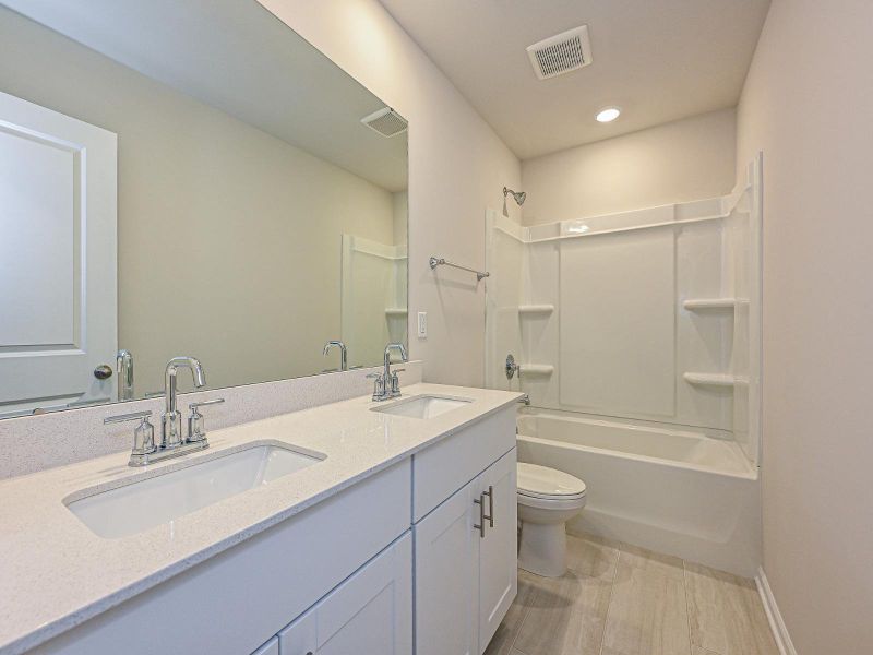 The secondary bathroom offers dual sinks and plenty of counter space.