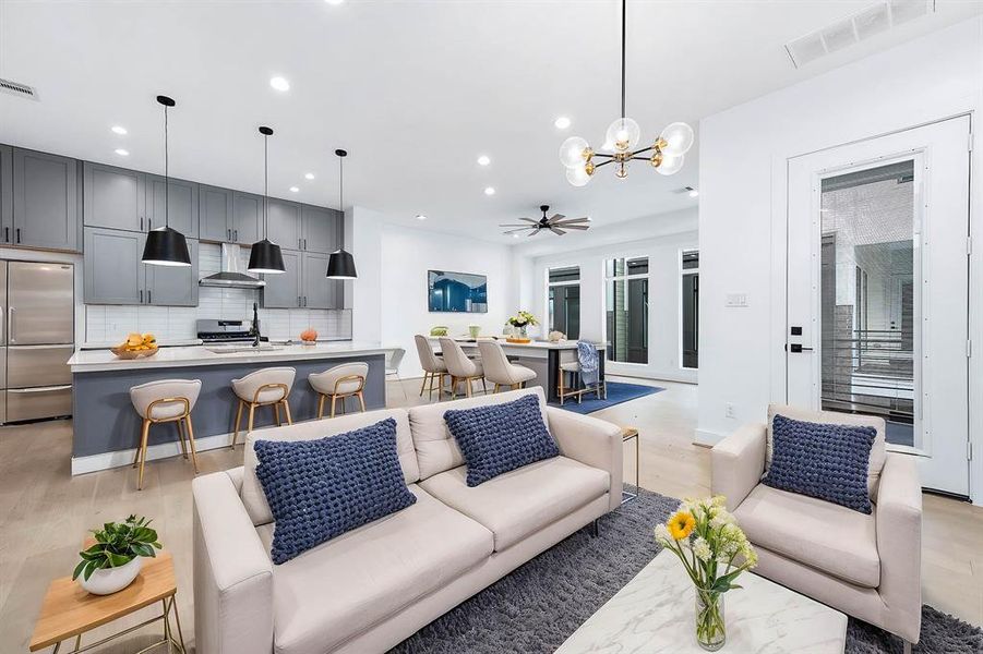 This is a graet shot of the living room, dining room, kitchen open concept with engineered wood floors. This photos has been virtually staged.