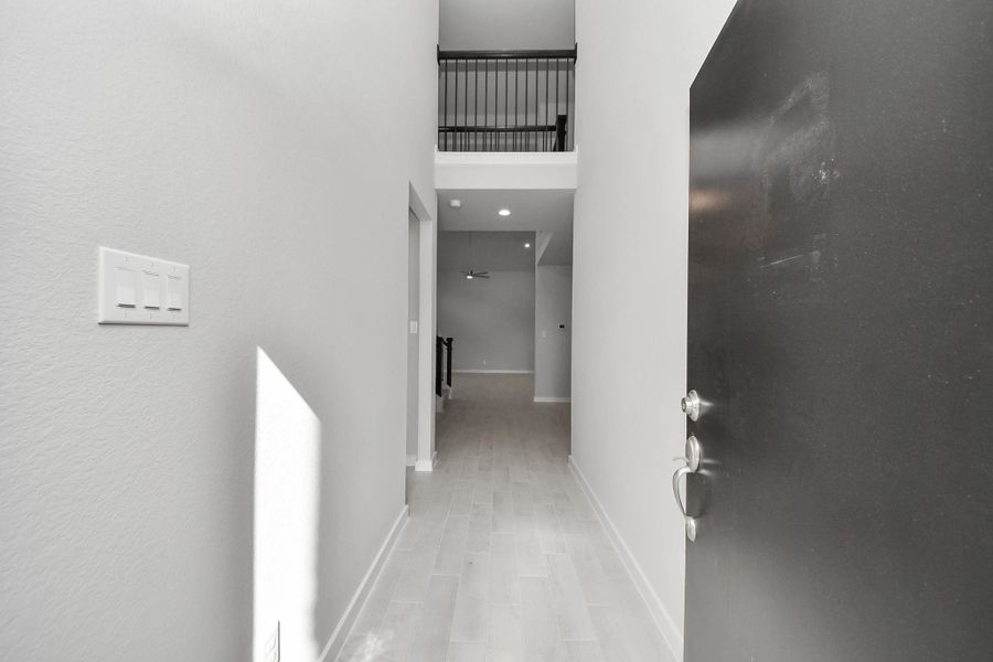 As you step into the threshold of this luxurious home, you'll soon be welcomed by an elegant glass door (to be installed). Inside, soaring ceilings amplify the spaciousness, while the refined wood-look tile flooring and oversized baseboards exude sophistication and charm.