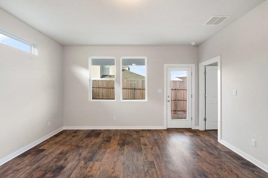 Empty room featuring dark wood-style flooring and baseboards