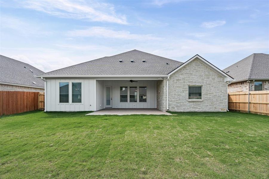 The property features a spacious backyard with a well-maintained lawn and a covered patio