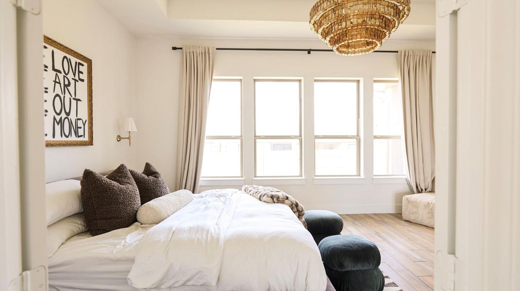 A primary bedroom offering abundant natural light through multiple windows and wood flooring. A primary bedroom offering abundant natural light through multiple windows and wood flooring.