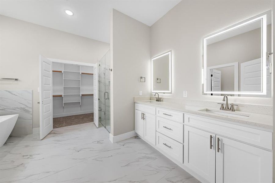 Bathroom in Primary bedroom with marble look tiles, double vanity, a marble finish shower, a soaking tub, and a spacious closet Bathroom in Primary bedroom with marble look tiles, double vanity, a marble finish shower, a soaking tub, and a spacious closet