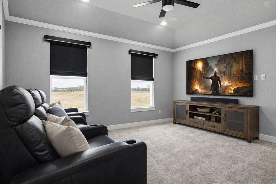 Carpeted cinema with crown molding, plenty of natural light, and ceiling fan. digitally staged.