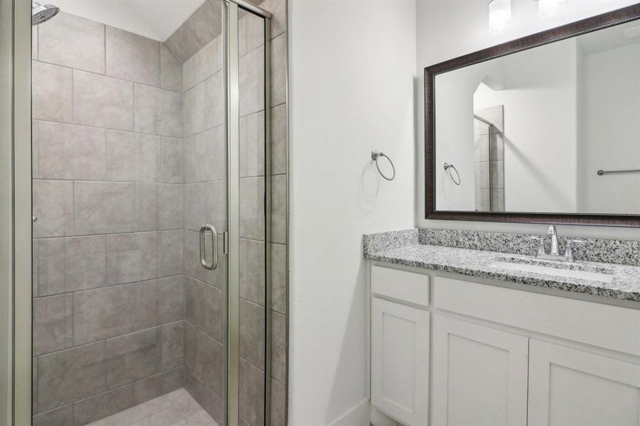 Bathroom with vanity and a shower with door