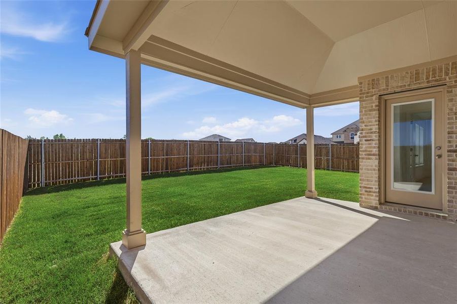 Covered patio with concrete slab, brick exterior wall, and direct access to a private backyard