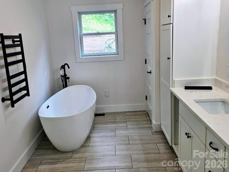 Ensuite bathroom with soaking tub and towel warmer