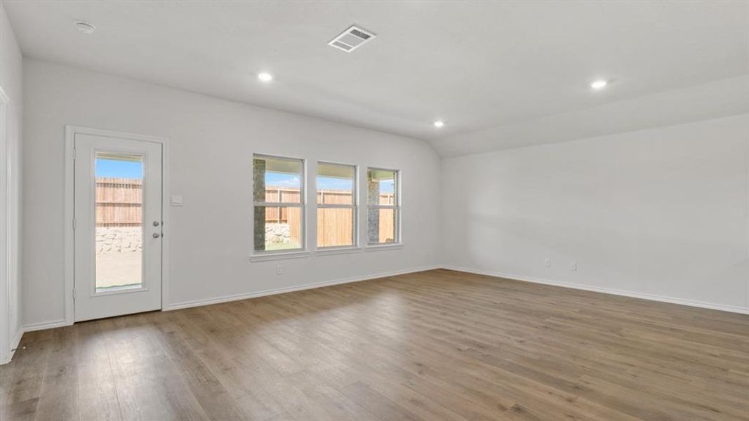 Empty room featuring lofted ceiling, dark wood-type flooring, and recessed lighting