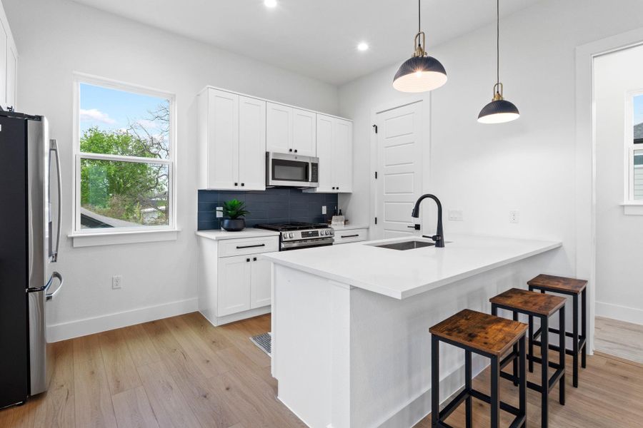 Clean lines and warm wood floors define this modern kitchen anchored by a central island.