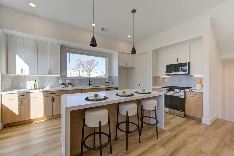 Natural light floods this stunning kitchen with views of East River overlooking the sink! This kitchen features European style white oak and white slim shaker soft-close cabinetry, beautiful custom tile backsplash, white quartz with a 2 inch thick waterfall island, and large walk-in corner pantry.