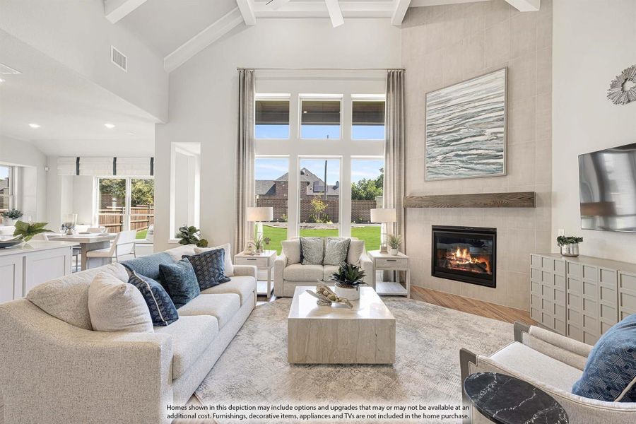 Bright living room with vaulted coffered ceiling, tile fireplace, and large windows overlooking backyard