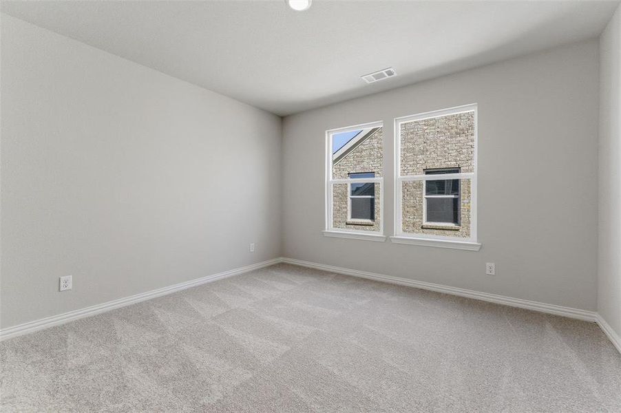 Unfurnished room featuring light carpet and baseboards