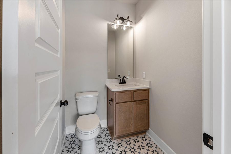 Half bathroom featuring vanity and toilet