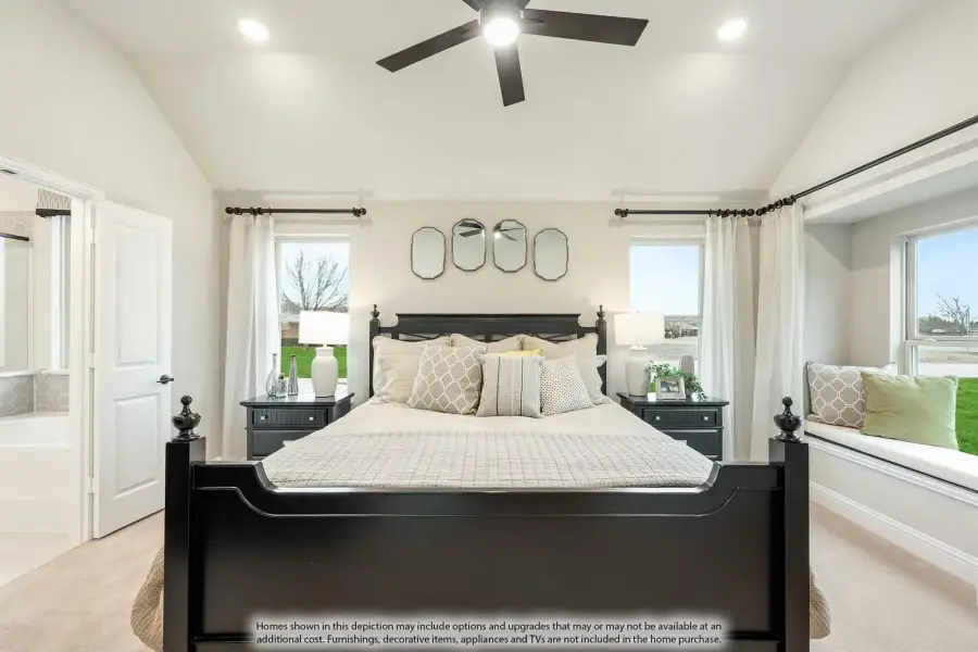 Bedroom with dark wood four-poster bed, ceiling fan, window seat, and neutral carpet