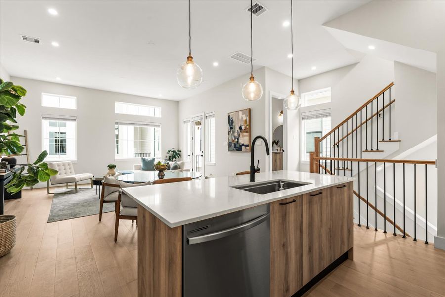 An oversized quartz island anchors the kitchen while the open layout creates an easy connection between the kitchen, dining, and living spaces.