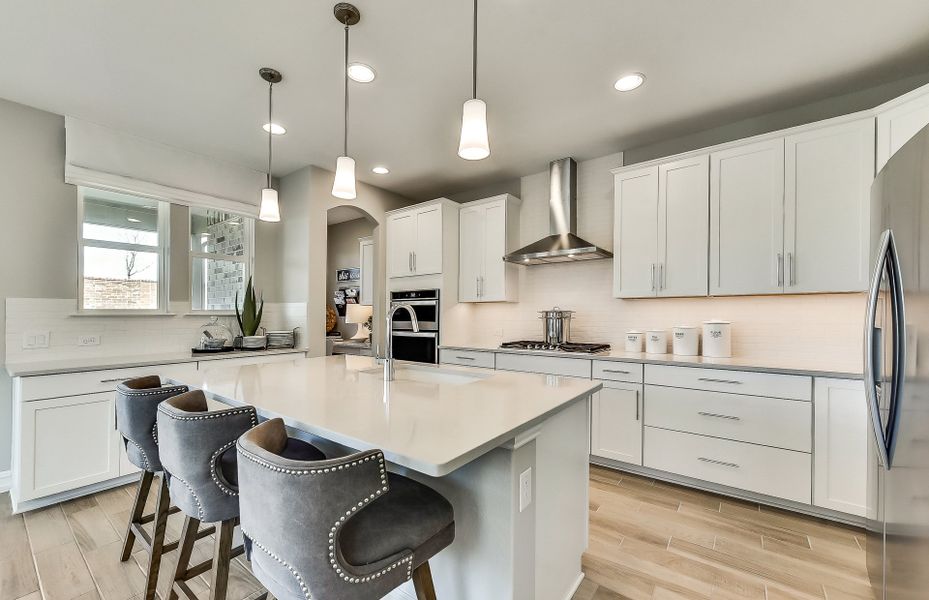 Spacious kitchen with recessed and pendant lightin